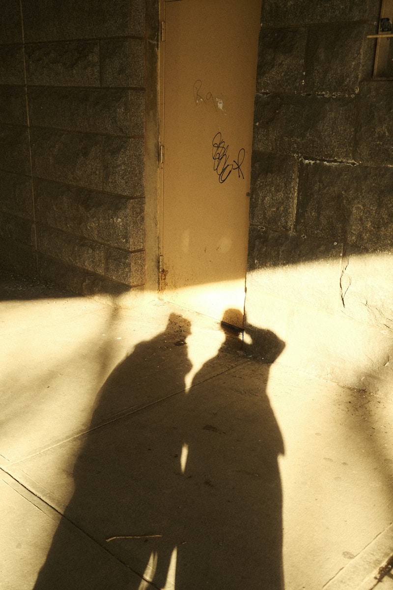 A shadow of a person standing on a sidewalk