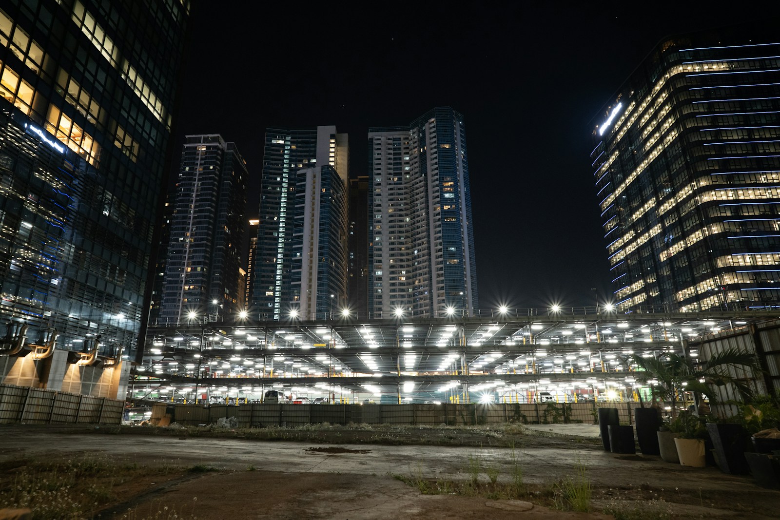 Modern city buildings illuminated at night with lights.