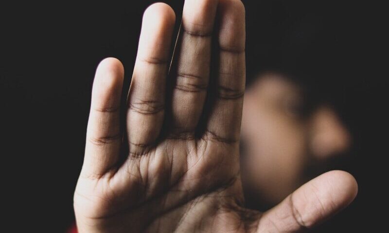 persons left hand on black background
